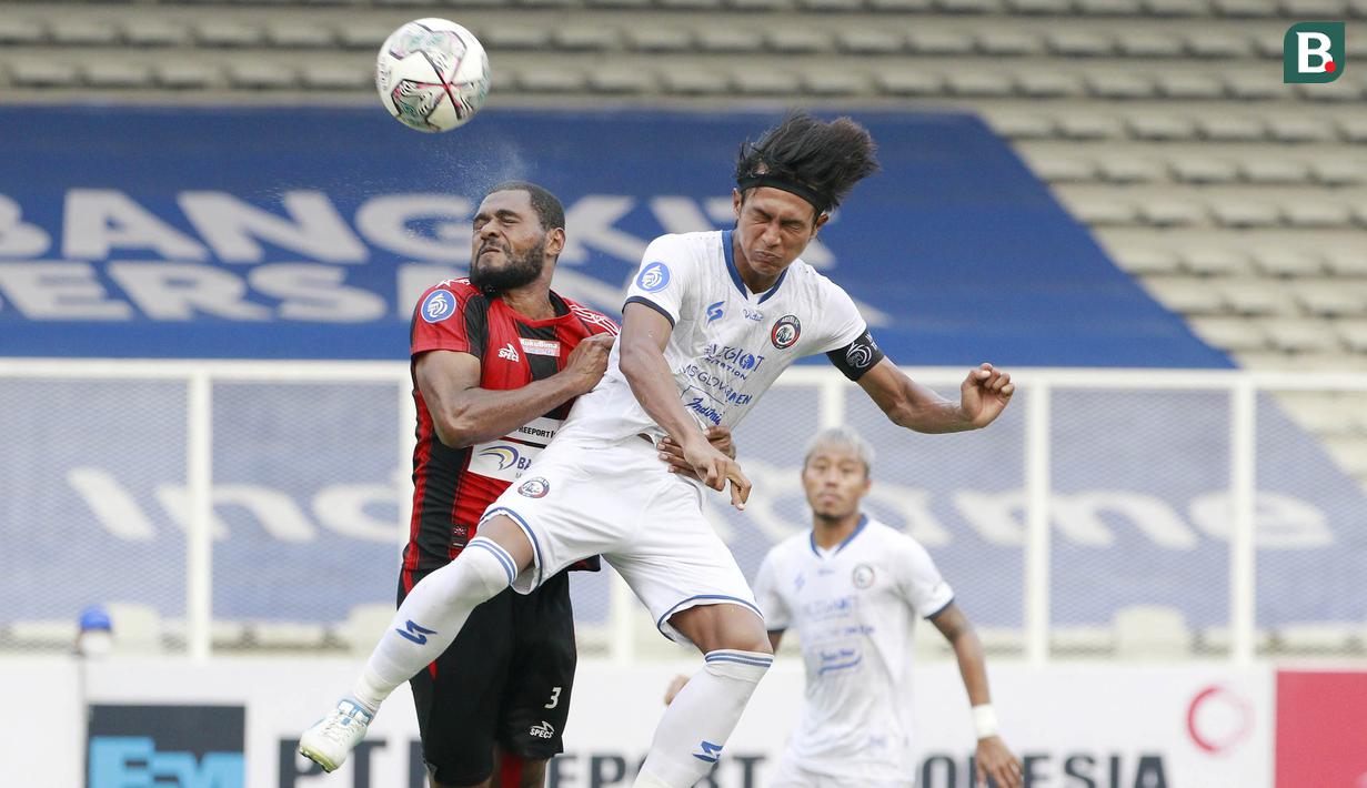 Pemain Persipura Jayapura, Donny Monim (kiri) berduel udara dengan pemain Arema FC, Johan Alfarizi dalam laga pekan ke-5 BRI Liga 1 2021/2022 di Stadion Madya, Jakarta, Rabu, (29/9/2021). Persipura kalah 0-1. (Bola.com/ M Iqbal Ichsan)