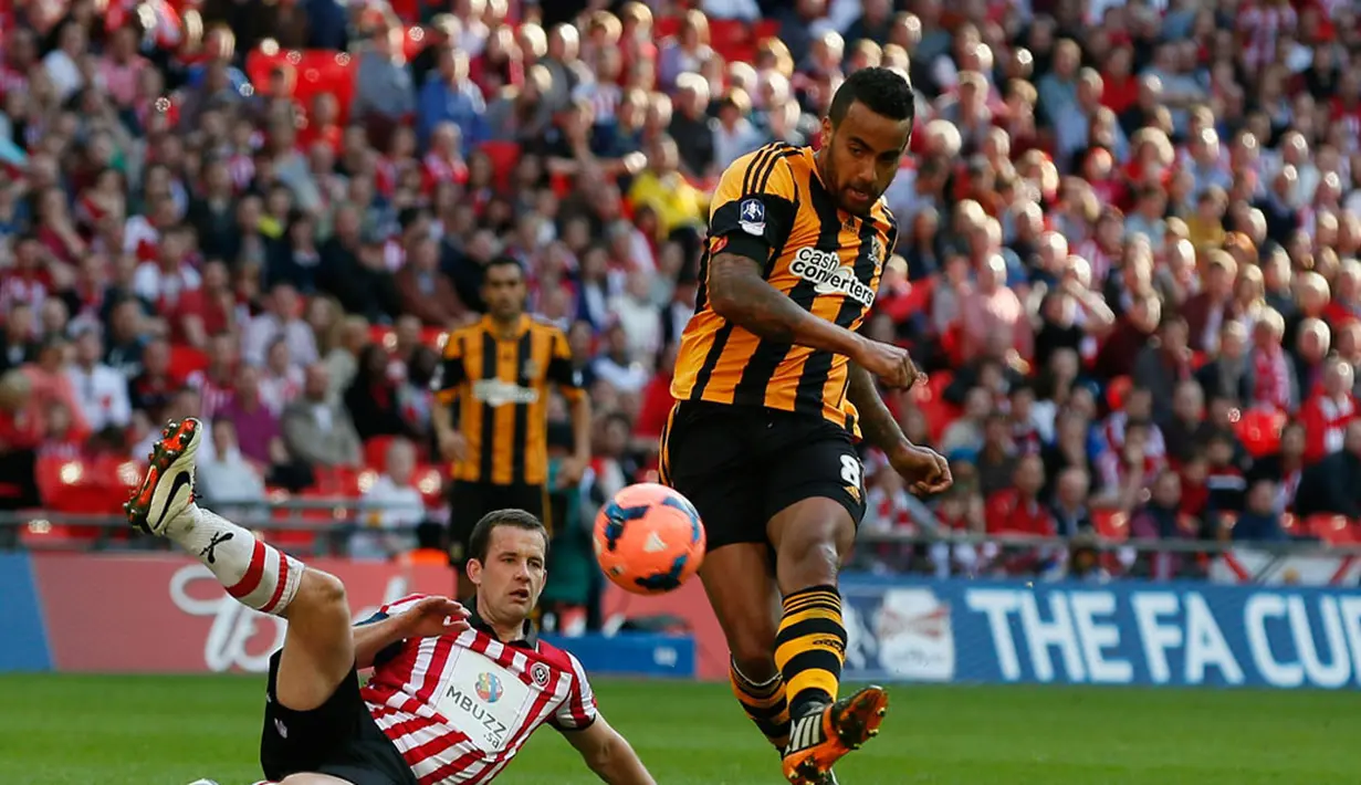 Pemain Hull City, Tom Huddlestone (kanan) melepaskan tendangan keras ke gawang Sheffield United saat berlaga di semifinal Piala FA di Stadion Wembley, London (13/4/2014). (REUTERS/Stefan Wermuth)