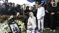 Bunga Citra Lestari atau BCL bersama anaknya Noah Sinclair memandangi foto Ashraf Sinclair saat pemakaman di San Diego Hills, Karawang, Jawa Barat, Selasa (18/2/2020). Ashraf Sinclair mengembuskan napas terakhir pukul 04.51 WIB pagi tadi. (Liputan6.com/Faizal Fanani)