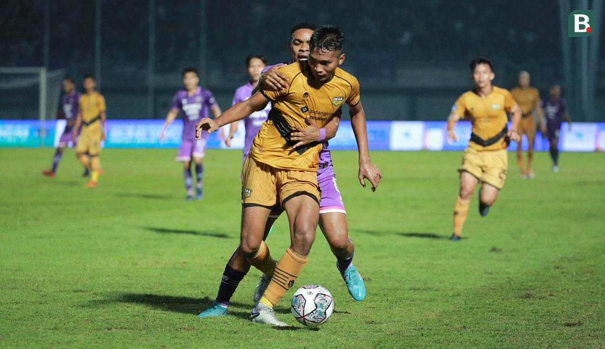 <p>Pemain Persita Tangerang, Osas Saha (belakang) berebut bola dengan pemain Dewa United, Mochamad Zaenuri dalam laga pekan ke-3 BRI Liga 1 2022/2023 antara Persita Tangerang melawan Dewa United di Indomilk Arena, Tangerang, Minggu (7/8/2022) malam WIB. (Bola.com/M Iqbal Ichsan)</p>
