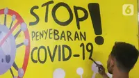 Mahasiswa melukis mural bertemakan sosialisasi pencegahan Covid-19 di kolong jalan tol dalam kota, Kebun Nanas, Jakarta, Jumat (4/12/2020). Kegiatan sekitar 90 tiang kolong tol sepanjang jalan MT Haryono ini difasilitasi Satgas Covid-19. (merdeka.com/Arie Basuki)