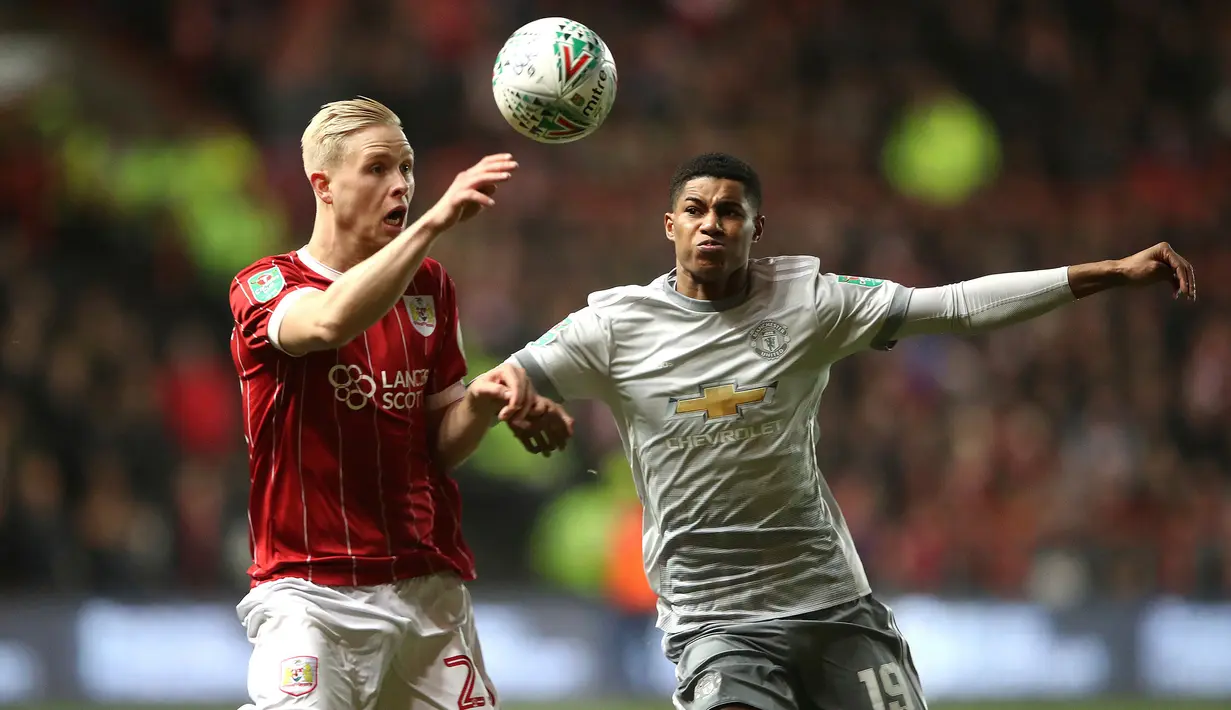 Pemain Bristol City, Hordur Bjorgvin Magnusson berebut bola dengan pemain Manchester United, Marcus Rashford pada perempat final Piala Liga Inggris di Ashton Gate, Kamis (21/12). MU gagal ke babak empat besar setelah kalah 1-2. (Nick Potts/PA via AP)