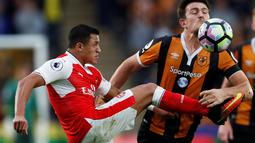 Pemain Arsenal, Alexis Sanchez, berebut bola dengan pemain Hull City, Harry Maguire, pada laga lanjutan Premier League, di KCOM Stadium, Sabtu (17/9/20106). (Action Images via Reuters/Lee Smith)