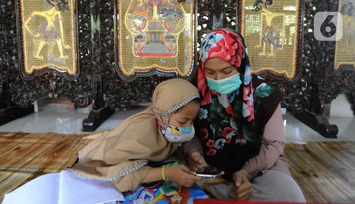 Siswa belajar secara daring menggunakan fasilitas wifi gratis di Perumahan Pondok Mulya I, Beji, Depok, Jawa Barat, Rabu (29/7/2020). Fasilitas tersebut sebagai bentuk kepedulian Sri Wiwoho atas kesulitan warga dalam menyediakan dana belajar daring. (merdeka.com/Arie Basuki)