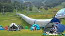 Warga berkemah di sebuah kawasan resor di Kota Jilin, Provinsi Jilin, China pada 19 Juli 2020. Arena ski di kawasan resor itu diubah menjadi ladang bunga, seluncuran, dan beragam proyek pariwisata rekreasi lainnya guna menarik wisatawan pada musim panas. (Xinhua/Yan Linyun)