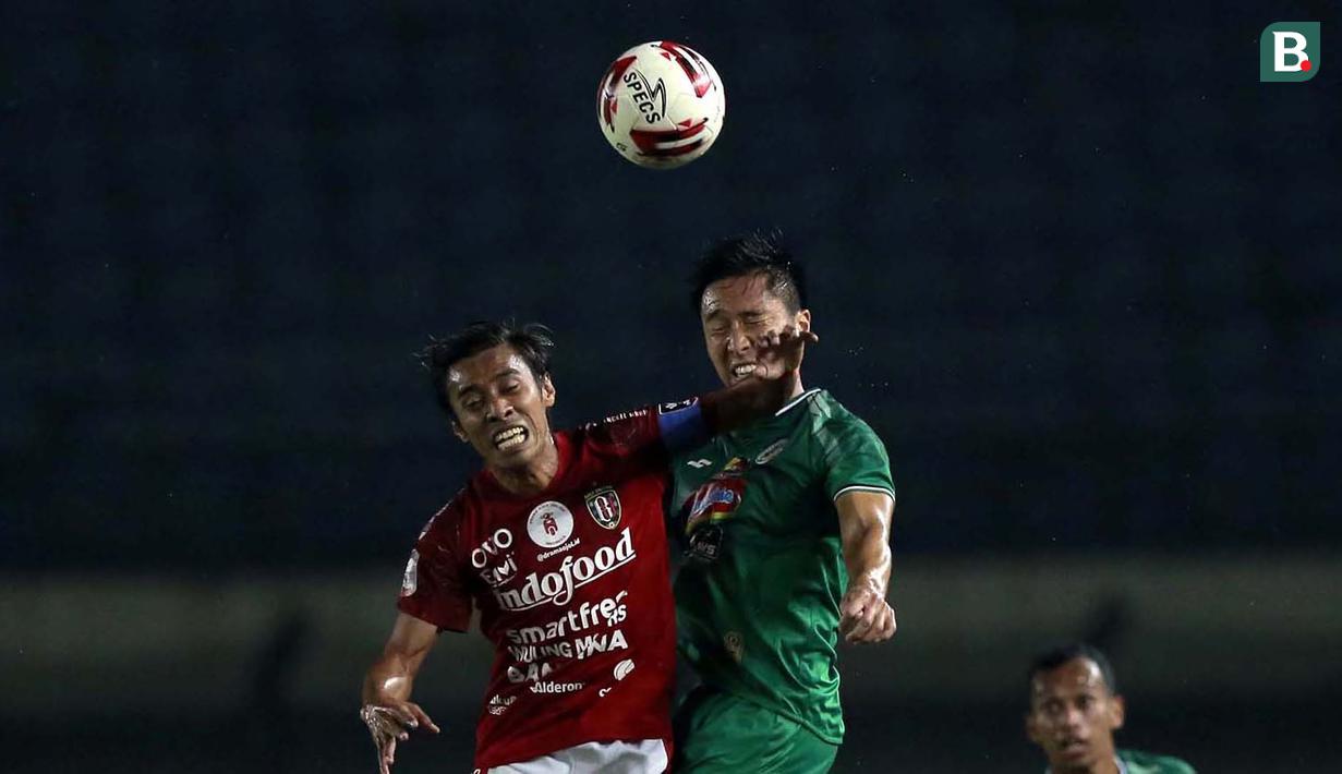 Bek PS Sleman, Arthur Daniel Irawan (kanan) berduel udara dengan gelandang Bali United, Fadil Sausu dalam laga perempatfinal Piala Menpora 2021 di Stadion Si Jalak Harupat, Bandung, Senin (12/4/2021). (Bola.com/Ikhwan Yanuar)