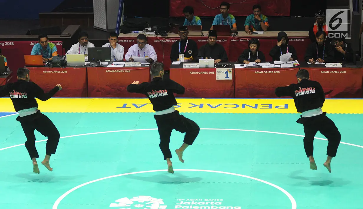Nunu Nugraha, Asep Yuldan Sani, dan Anggi Faisal Mubarok tampil dalam babak final pencak silat beregu putra Asian Games 2018 di TMII, Jakarta, Senin (27/8). Pencak silat beregu putra menyumbang emas ke-15 untuk Indonesia. (Merdeka.com/Arie Basuki)