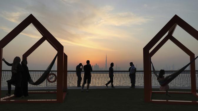 Orang-orang menikmati pemandangan cakrawala kota dengan latar gedung tertinggi di dunia Burj Khalifa, di Dubai, Uni Emirat Arab (18/10/2019). Burj Khalifa yang sebelumnya bernama Burj Dubai, adalah sebuah pencakar langit di Dubai, UEA yang diresmikan pada 4 Januari 2010. (AP Photo/Kamran Jebreili)