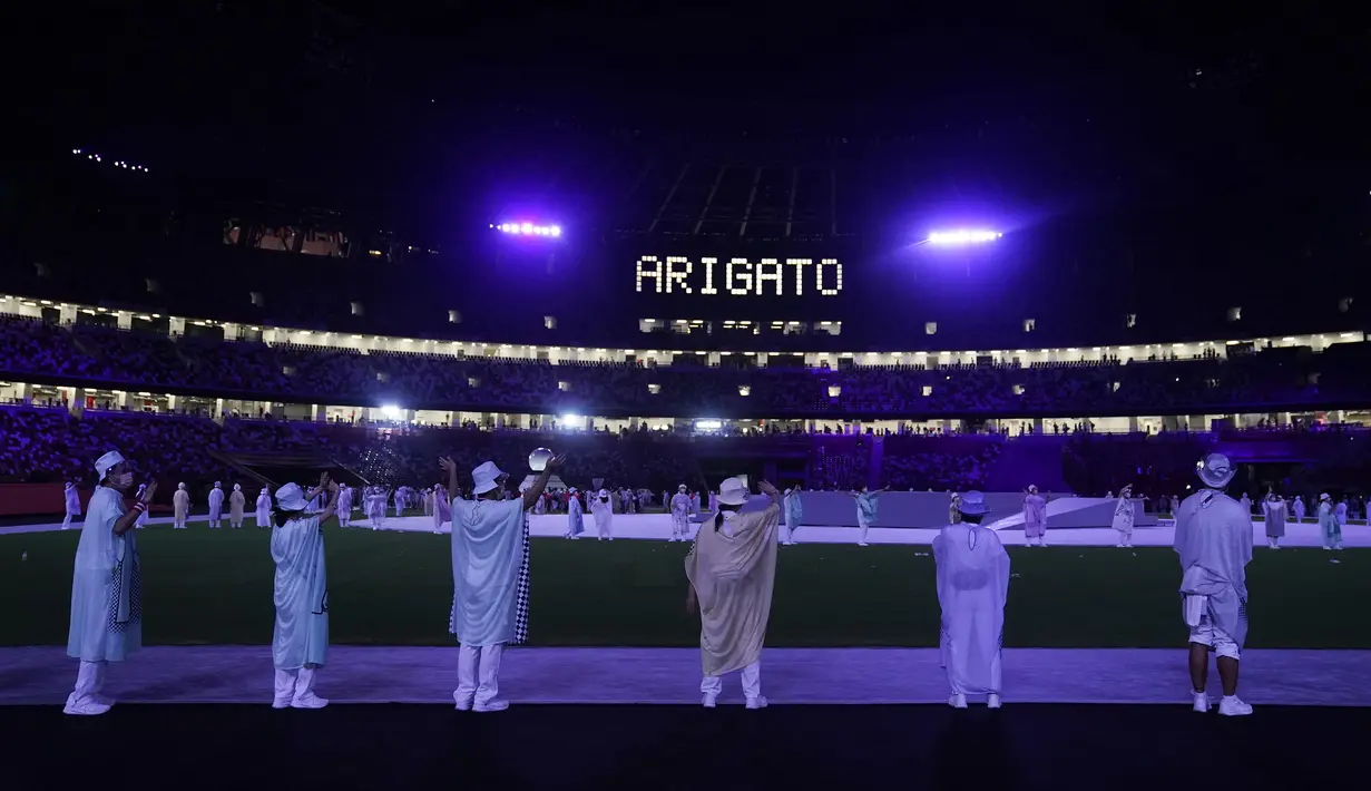Para penampil melambai saat para atlet meninggalkan lapangan setelah upacara penutupan Olimpiade Musim Panas 2020, Minggu, 8 Agustus 2021, di Tokyo, Jepang. (AP/Jae C.Hong)