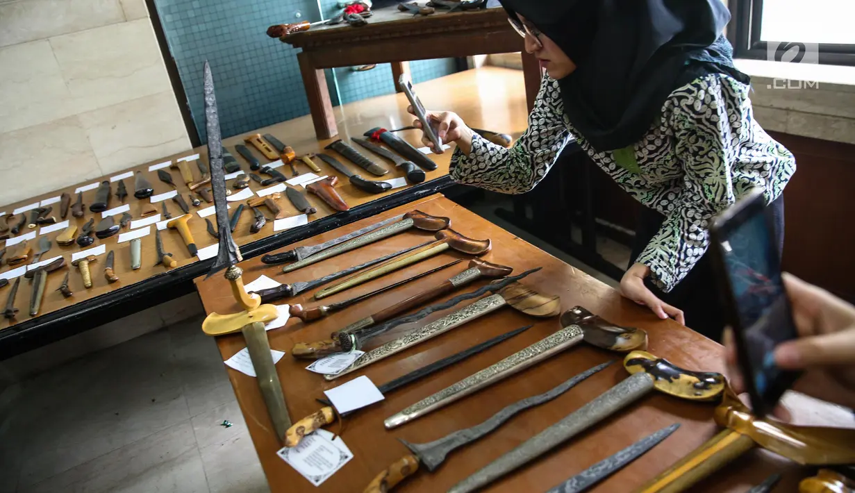 Pengunjung mengabadikan salah satu keris dari Paguyuban Tosan Aji Jayakarta yang dipamerkan dalam acara silaturrahim Kebudayaan di Gedung PBNU, Jakarta, Jumat (28/7). Sebanyak 99 keris dari Bali dan Jawa dipamerkan. (Liputan6.com/Faizal Fanani)