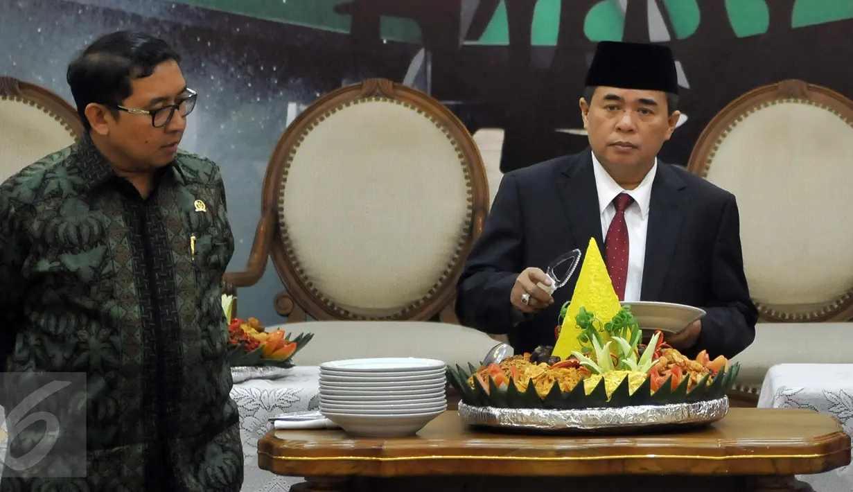 Ketua DPR RI Ade Komarudin didampingi Wakil Ketua DPR Fadli Zon (kiri) saat pemotongan tumpeng peresmian ruangan wartawan parlemen di Gedung Nusantara III kompleks parlemen, Senayan, Jakarta, Selasa (5/4). (Liputan6.com/Johan Tallo)