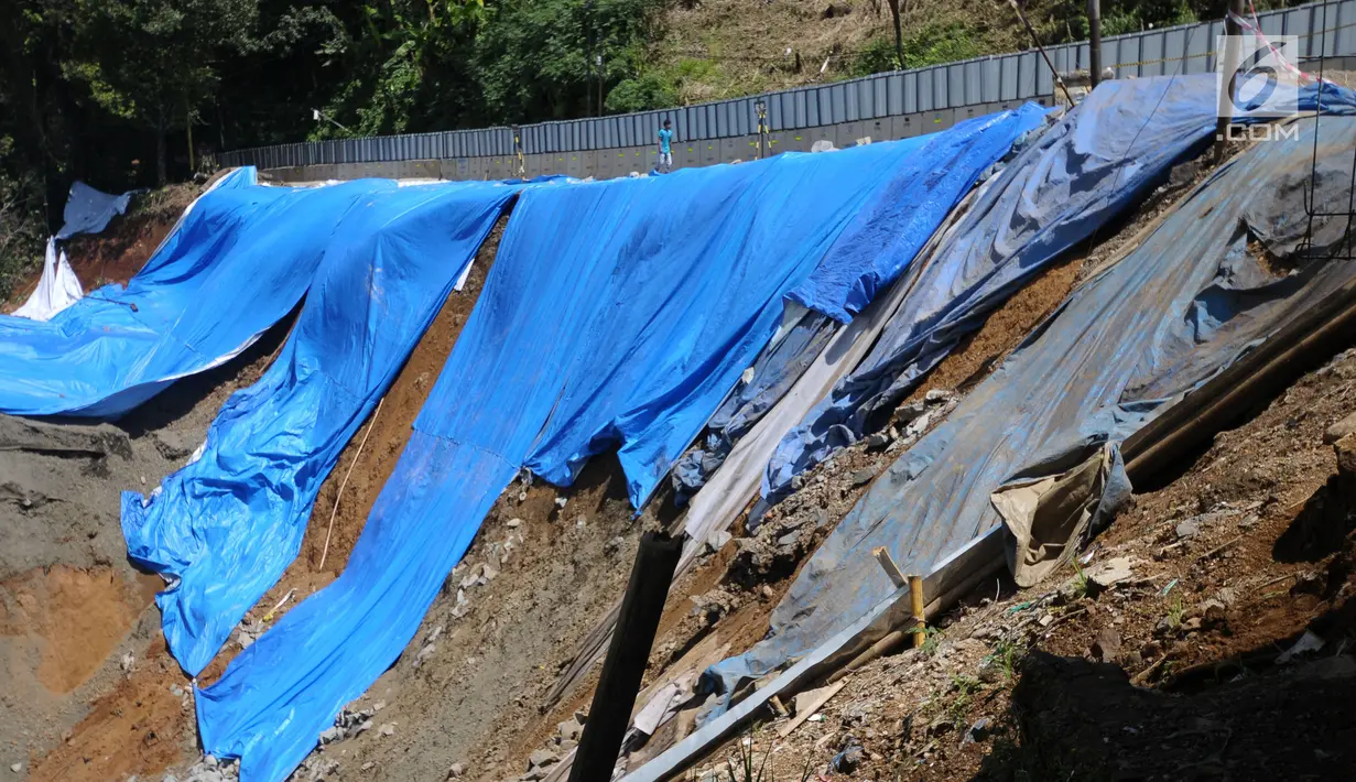 Pekerja melintasi area lokasi longsor di kawasan Ciloto, Cianjur, Jawa Barat, Sabtu (31/3). Longsor yang terjadi pada Rabu (28/3) lalu diduga adanya pergerakan tanah sehingga menyebabkan longsor. (Liputan6.com/Helmi Fithriansyah)