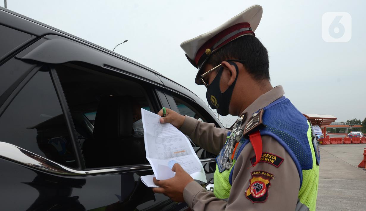 Polisi memeriksa kendaraan di Gerbang Tol Palimanan, Jakarta, Jumat, (7/5/2021). Gerbang Tol Palimanan terpantau sepi pemudik dan didominasi oleh kendaraan angkutan barang pada hari kedua penyekatan. (merdeka.com/Imam Buhori)