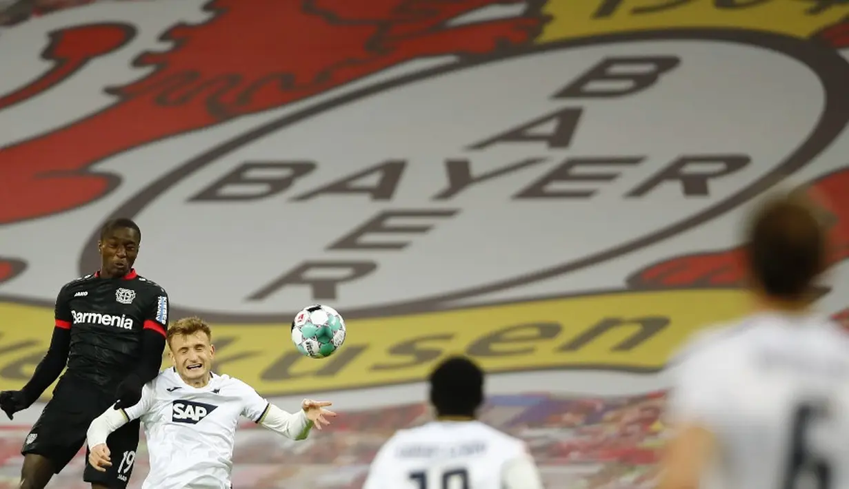 Pemain Bayer Leverkusen Moussa Diaby berebut bola dengan pemain Hoffenheim Stefan Posch pada pertandingan Bundesliga di Leverkusen, Jerman, 13 Desember 2020. Bayer Leverkusen menggeser Bayern Munchen dari puncak klesemen usai mengalahkan Hoffenheim dengan skor 4-1. (THILO SCHMUELGEN/POOL/AFP)