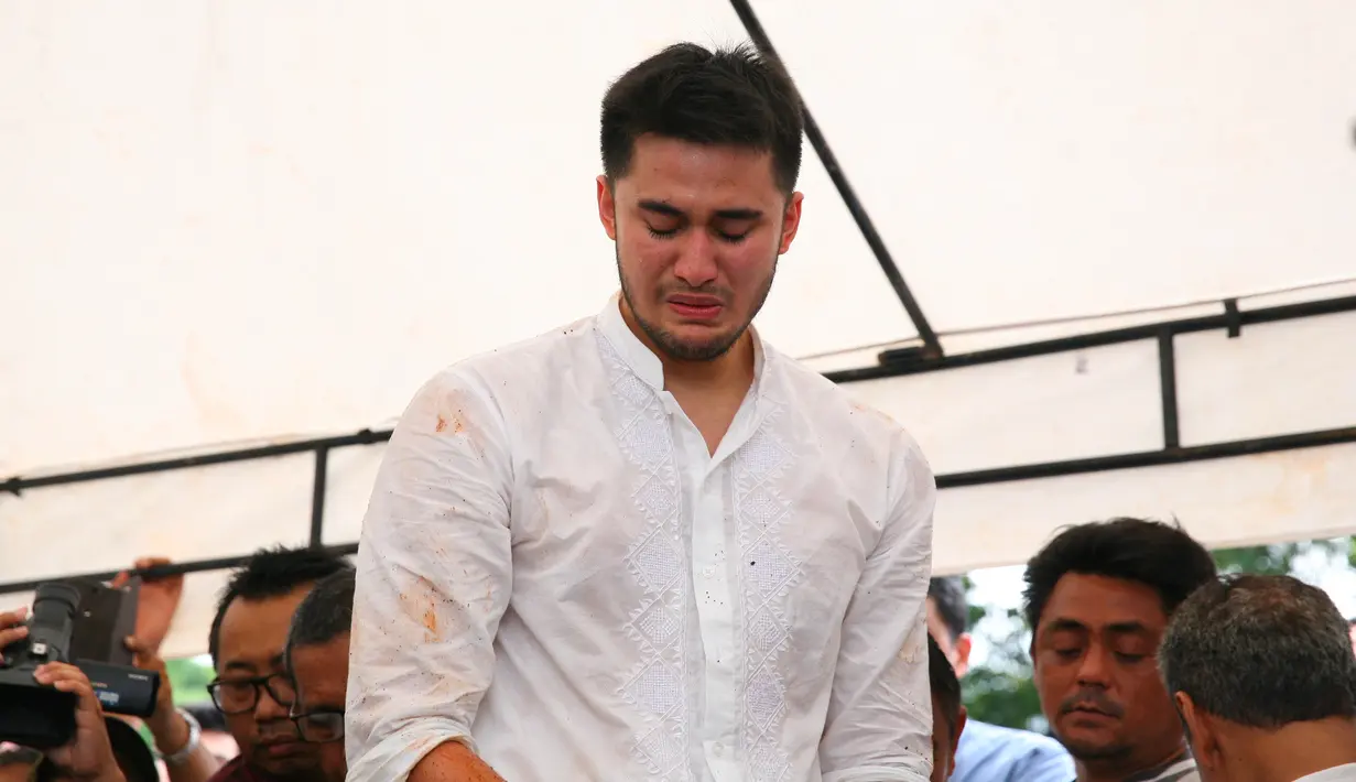 Kepedihan mendalam bagi anak Sys Ns. Air mata kembali mengalir menyaksikan ayahnya yang mulai di urug dengan tanah. (Nurwahyunan/Bintang.com)