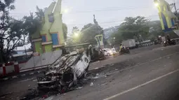 Mobil dibakar di luar Stadion Kanjuruhan, Malang, Jawa Timur, Minggu (2/10/2022). Sebanyak 127 orang tewas ketika para penggemar yang marah menyerbu lapangan sepak bola setelah pertandingan antara Arema FC dan Persebaya Surabaya pada 1 Oktober 2022. (PUTRI/AFP)