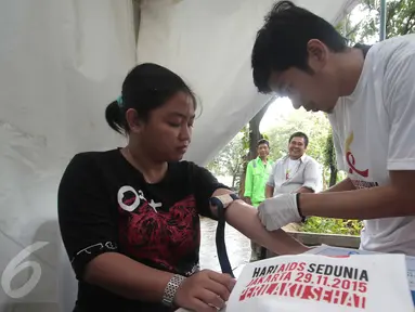 Pengunjung melakukan tes darah untuk mengecek HIV/AIDS  yang digelar Komisi Penanggulangan AIDS Provinsi (KPAP) DKI Jakarta sebagai bentuk peringatan hari AIDS sedunia di Taman Suropati, Menteng, Jakarta, Minggu (29/11/2015). (Liputan6.com/Angga Yuniar)
