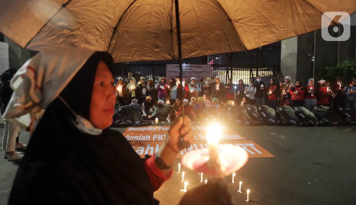 Massa menggelar aksi dengan membawa lilin dan doa bersama lintas agama di depan Gedung DPR, Jakarta, Kamis (16/3/2023). Dalam aksinya, mereka menuntut agar pimpinan DPR menetapkan RUU PPRT sebagai RUU INISIATIF DPR di Rapat Paripurna pada Selasa, 21 Maret 2023 mendatang. (Liputan6.com/Johan Tallo)