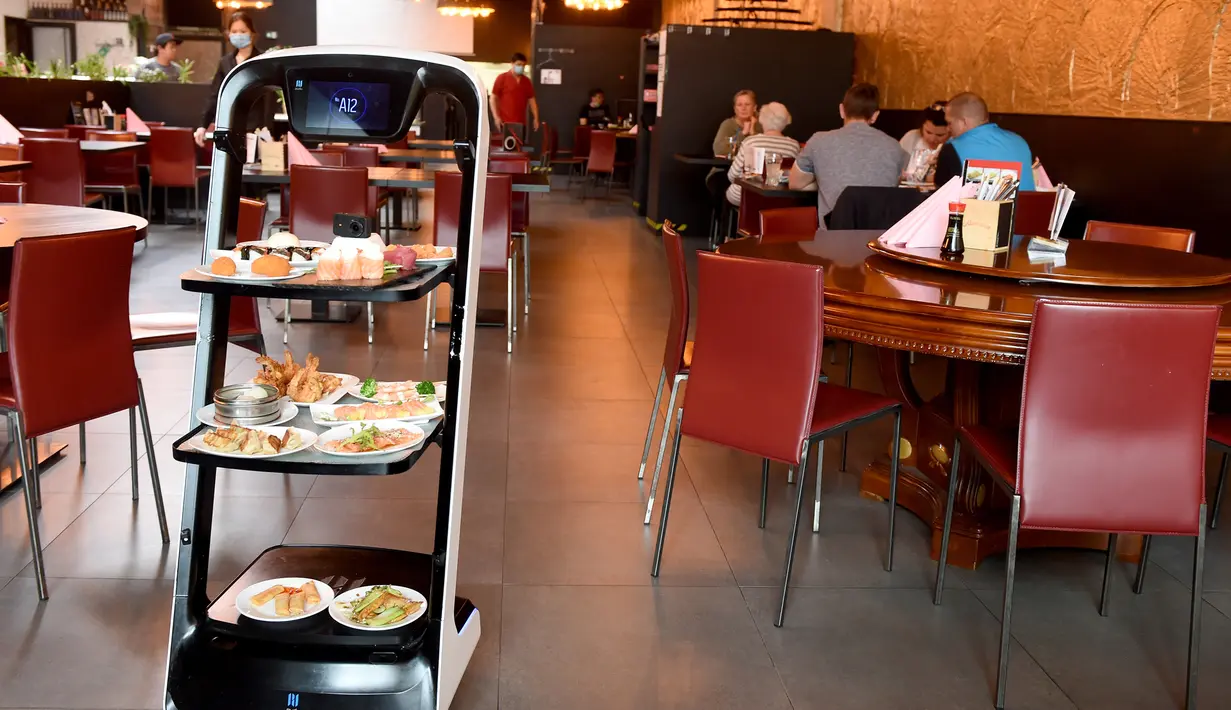 Robot mengantarkan makanan di restoran Asia di Wina, Austria, Kamis (28/5/2020). Restoran tersebut menggunakan robot untuk mengantar makanan guna mengurangi kontak yang tidak diperlukan antara pelayan dan pelanggan di tengah pandemi virus corona COVID-19. (Xinhua/Guo Chen)