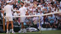 Petenis Italia, Jannik Sinner (kiri), berjabat tangan dengan petenis Serbia, Novak Djokovic, setelah memenangkan pertandingan semifinal tunggal putra mereka pada hari&nbsp;ke-12 Kejuaraan Wimbledon 2025 di All England Lawn Tennis and Croquet Club di Wimbledon, London barat daya, pada 11 Juli 2025. (HENRY NICHOLLS/AFP)