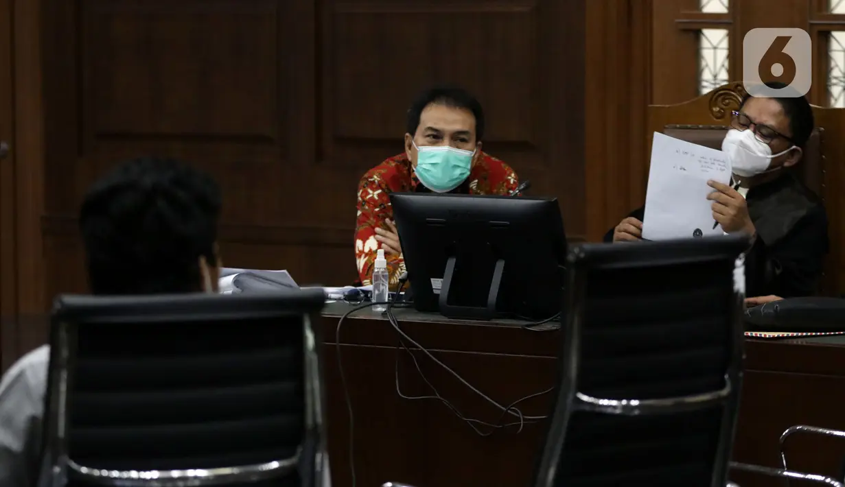 Mantan Wakil Ketua DPR Azis Syamsuddin (tengah) saat mengikuti sidang lanjutan dugaan suap penanganan perkara korupsi di Lampung Tengah, Pengadilan Tipikor Jakarta, Senin (13/12/2021). Sidang bergaendakan pemeriksaan keterangan saksi-saksi. (Liputan6.com/Helmi Fithriansyah)