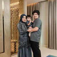 Aurel membagikan potret keluarga kecilnya dalam balutan outfit yang kompak. Bernuansa hijau tua, Aurel mengenakan abaya cantik dengan detail kerut di bagian rok, dipadunya dengan hijab berwarna hijau polos yang senada. Sedangkan Atta memilih kemeja bermotif seragam dan celana panjang hitam, menggendong Ameena yang memakai dress serupa dengan Aurel. Foto: Instagram.