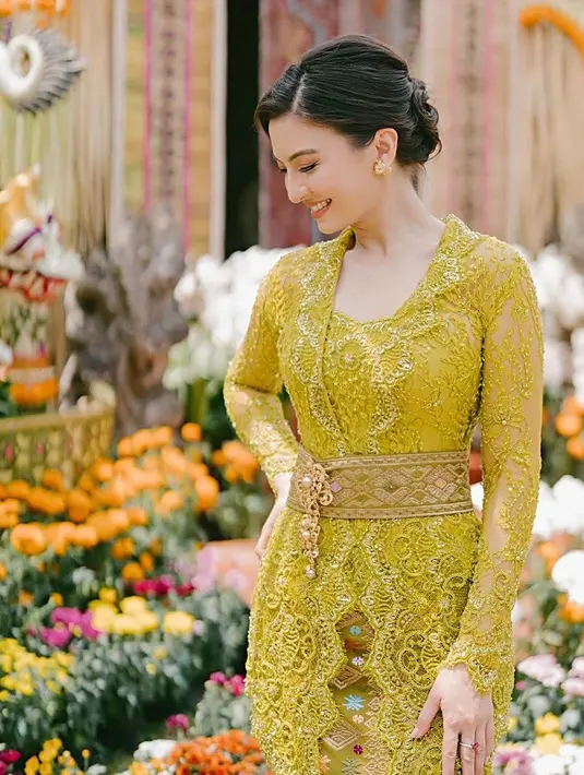 Penampilan memesona Raline Shah dibalut kebaya Bali warna hijau lime saat jadi bridesmaid dan pengiring pengantin rekannya. Kebaya rancangan Anggi Asmara itu dilengkapi sabuk prada, serta dipadukan kain songket warna senada.