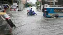 Warga berkendara ke tempat kerja meski banjir melanda Metropolitan Manila, Filipina, Jumat (20/7). Selain bagian Metropolitan Manila, banjir juga terjadi di provinsi lain. (AP Photo/Bullit Marquez)