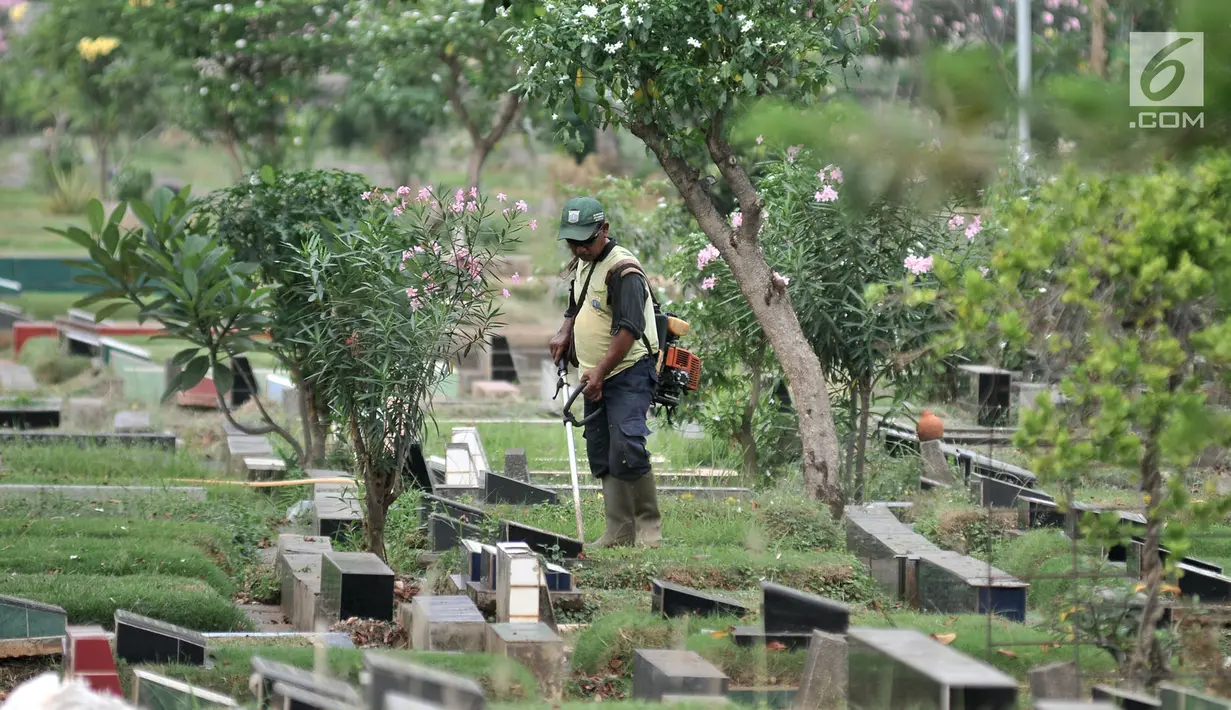 Petugas kebersihan memotong rumput makam di TPU Karet Bivak, Jakarta, Kamis (12/7). Data Dinas Kehutanan DKI mencatat dari 611,59 hektare lahan makam yang sudah dibebaskan, 60 persen atau 365,13 hektare sudah dipakai. (Merdeka.com/Iqbal Nugroho)