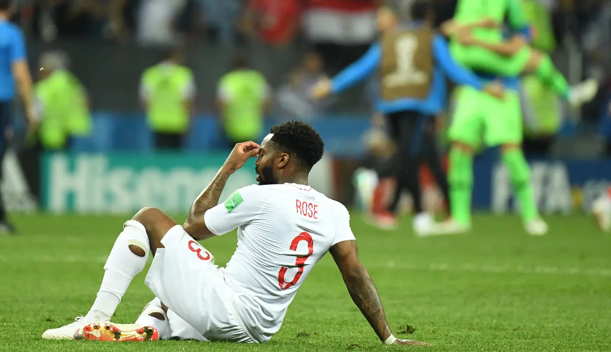 Bek timnas Inggris, Danny Rose terlihat kecewa sambil duduk di lapangan seusai babak semifinal Piala Dunia 2018 melawan Kroasia di Stadion Luzhniki, Rabu (11/7). Rose menyita perhatian lantaran mengenakan kaus kaki yang berlubang. (AFP/Kirill KUDRYAVTSEV)