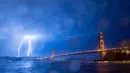 Kilatan petir hiasi jembatan Golden Gate di San Francisco, California, AS (11/9). Petir merupakan Gejala alam yang biasanya muncul pada musim hujan di saat langit memunculkan kilatan cahaya sesaat yang menyilaukan. (AFP Photo/Josh Edelson)