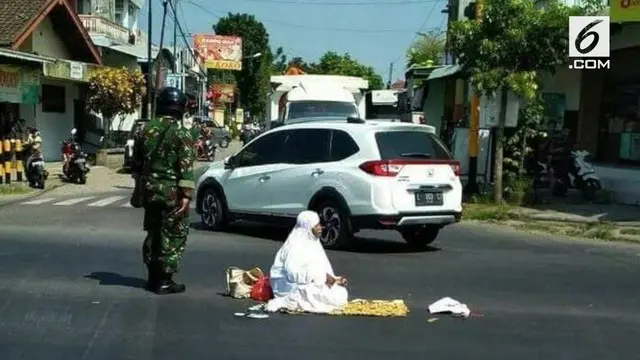 Pengguna jalan yang melintas di Perempatan Gragalan Tulungagung, dikejutkan dengan aksi seorang wanita yang salat di tengah jalan raya. Padahal, kondisi arus lalu lintas saat kitu cukup ramai.