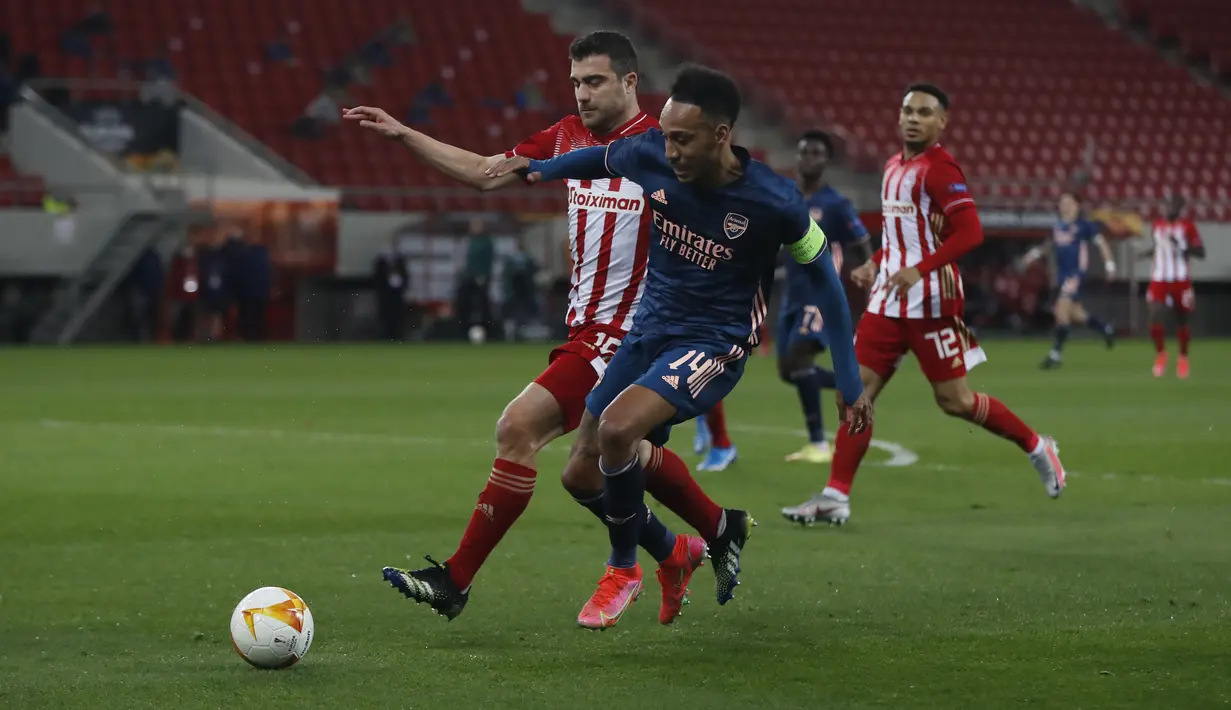 Striker Arsenal, Pierre-Emerick Aubameyang membawa bola dari kawalan bek Olympiakos, Sokratis Papastathopoulos pada leg pertama babak 16 besar Liga Europa di stadion Georgios Karaiskakis, Athena, Jumat (12/3/2021).Arsenal dapat melaju ke perempatfinal meski kalah 0-2. (AP Photo/Thanassis Stavrakis)