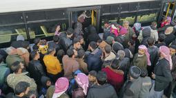 Foto udara menunjukkan pengungsi Suriah yang tinggal di Turki menunggu untuk naik bus melalui penyeberangan perbatasan Bab al-Hawa utara, pada 17 Februari 2023, saat mereka kembali ke Suriah setelah gempa bumi yang mematikan. Perubahan aturan yang dirancang untuk menyatukan kembali keluarga di kedua sisi perbatasan yang dilanda bencana 6 Februari, yang telah menewaskan lebih dari 41.000 orang dan membuat jutaan orang mengungsi di kedua negara. (AFP/Omar Haj Kadour)