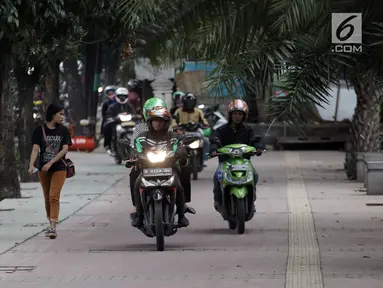 Sejumlah pengendara sepeda motor nekat menaiki jalur trotoar untuk menghindari kemacetan di Jalan Casablanca, Jakarta, Senin (8/1) (Liputan6.com/Arya Manggala Nuswantoro)