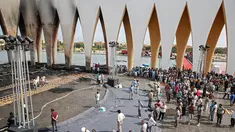 Orang-orang berada di paviliun utama situs Festival Film El Gouna yang hangus terbakar 
di pantai Laut Merah Mesir (12/10/2021). Kebakaran sempat mengancam pembatalan festival sebelum dikendalikan, kata para pejabat setempat. (AFP)