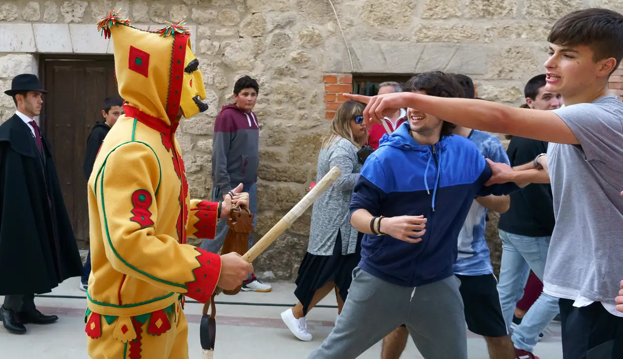 Pria berkostum setan mengejar kerumunan orang selama tradisi melompati bayi (El Colacho) di desa Castrillo de Murcia, Minggu (3/6). Festival ini dimulai ketika kerumunan orang termasuk para orang tua dari bayi-bayi  sudah berkumpul. (AFP/CESAR MANSO)