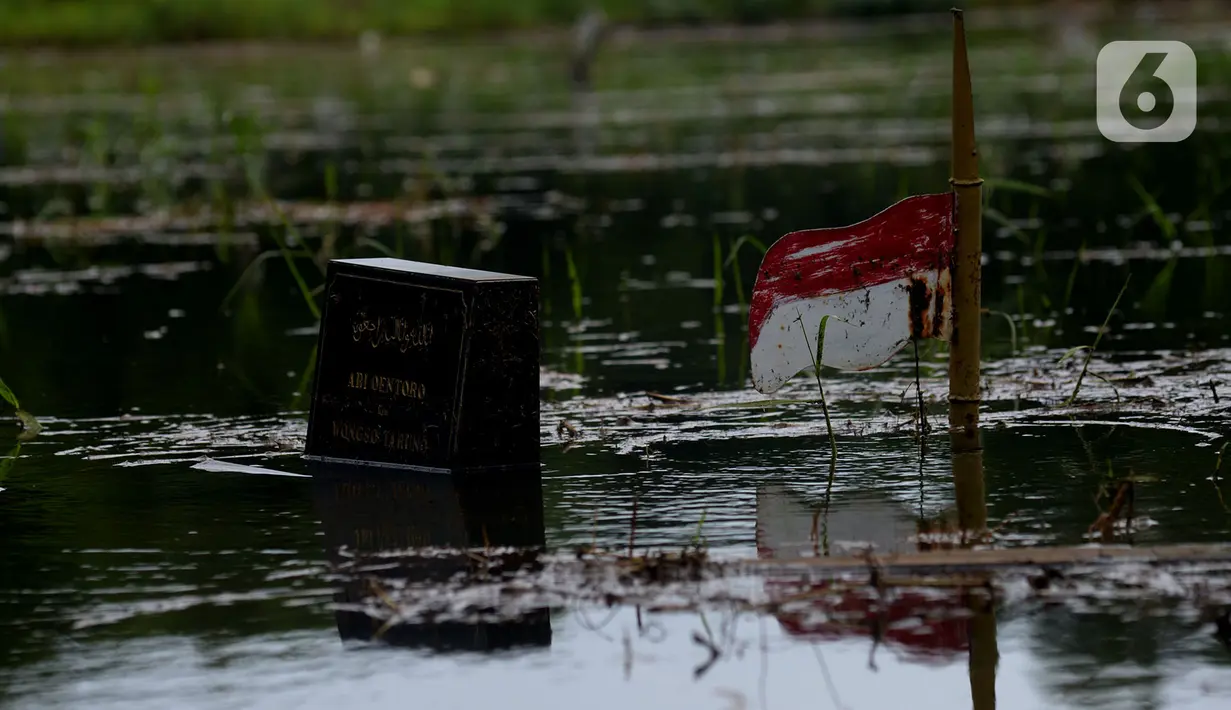 Salah satu makam di Tempat Pemakaman Umum (TPU) Tanah Kusir yang terendam banjir, Jakarta, Jumat (3/1/2020). TPU Tanah Kusir terendam banjir setelah Kali Pesanggrahan meluap akibat intensitas hujan  yang tinggi pada Rabu lalu. (merdeka.com/Imam Buhori)