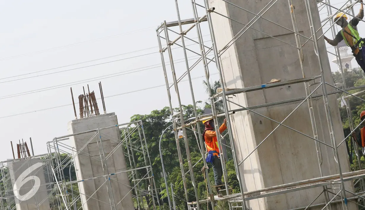Pekerja menyelesaikan pembangunan proyek light rail transit (LRT) koridor Cibubur-Cawang di tepi Tol Jagorawi, Jakarta, Senin (19/9). Proyek transportasi dengan panjang lintasan mencapai 14,3km tersebut telah mencapai 10%. (Liputan6.com/Immanuel Antonius)