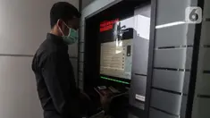 Pegawai memasukkan buku ke dalam mesin book drop di Perpustakaan Nasional, Jakarta. Kamis (18/3/2021). Perpustakaan Nasional menyediakan layanan pengembalian buku mandiri untuk pengunjung melalui mesin book drop. (Liputan6.com/Johan Tallo)