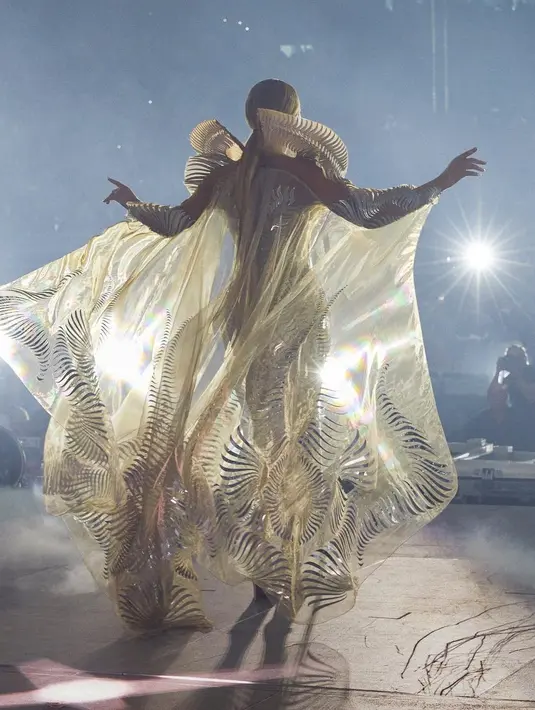 Di lengannya, terpasang jubah mutiara yang mengalir tertiup angin seperti sayap.