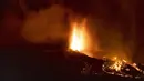 Lava dan asap mengalir dari letusan gunung berapi di pulau La Palma di Kepulauan Canaria, Spanyol, Minggu (19/9/2021). Letusan gunung berapi itu memuntahkan lava, debu, dan asap besar. (AP Photo/Jonathan Rodriguez)