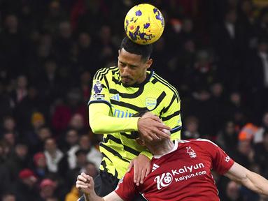 Pemain Arsenal, William Saliba, duel udara dengan pemain Nottingham Forest, Chris Wood, dalam laga Premier League 2023/2024 pekan 22 di Stadion City Ground, Rabu (31/1/2024). Arsenal menang dengan skor 2-1. (AP Photo/Rui Vieira)