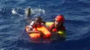 Petugas LSM Proactiva Open Arms menyelamatkan seorang imigran di lepas panti Libya, Laut Mediterania, Senin (29/8). Para penjaga pantai Italia berhasil menyelamatkan sekitar 6.500 imigran dari Eritrea dan Somalia. (REUTERS/Giorgos Moutafis)