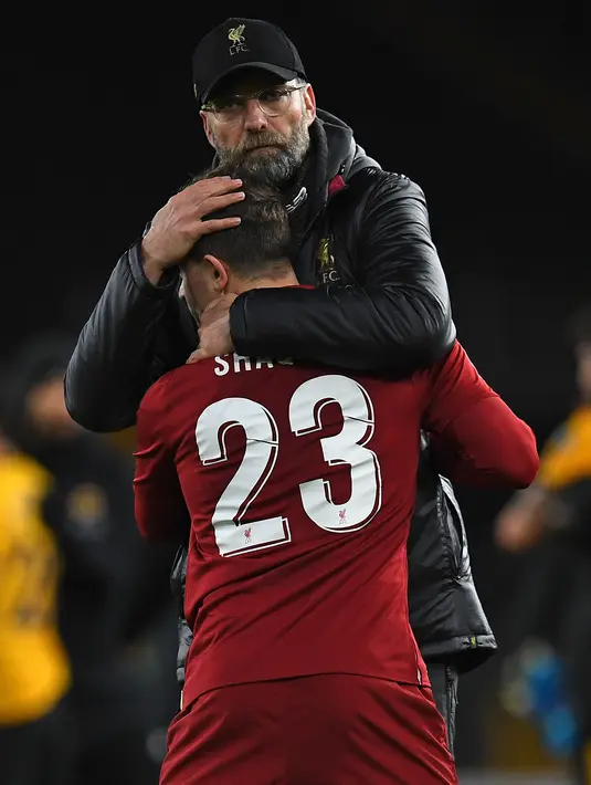 Manajer Liverpool Jurgen Klopp memeluk gelandang Liverpool, Xherdan Shaqiri pada laga putaran ketiga Piala FA melawan Wolverhampton Wanderers di Molineux Stadium, Senin (7/1). Liverpool tersingkir dari Piala FA setelah takluk 1-2. (Paul ELLIS/AFP)