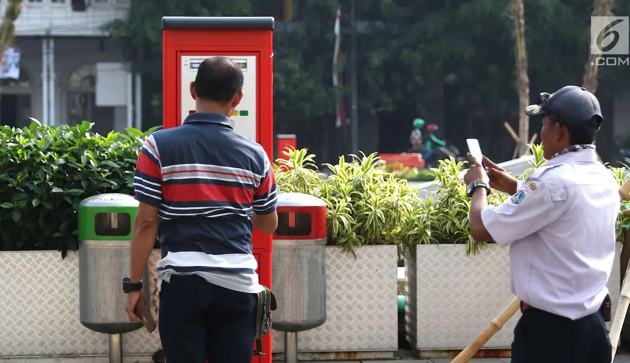 Seorang pria mengoperasikan mesin parkir meter di kawasan Kota Tua, Jakarta, Rabu (18/7). Sebanyak 13 Terminal Parkir Elektronik (TPE) dipasang di kawasan tersebut guna mengantisipasi membludaknya kendaraan yang parkir. (Liputan6.com/Immanuel Antonius)