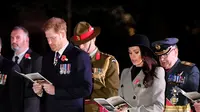 Meghan Markle dan tunangannya Pangeran Harry saat menghadiri kebaktian Anzac Day di Hyde Park Corner di London (25/4). Anzac Day adalah hari peringatan kebangsaan yang dirayakan di Australia dan New Zealand. (Toby Melville/Pool Photo via AP)
