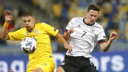 Pemain Jerman, Julian Draxler, berebut bola dengan pemain Ukraina, Vitaliy Mykolenko, pada laga UEFA Nations League di Stadion Olimpiyskiy, Minggu (11/10/2020). Jerman menang dengan skor 2-1. (AP Photo/Efrem Lukatsky)