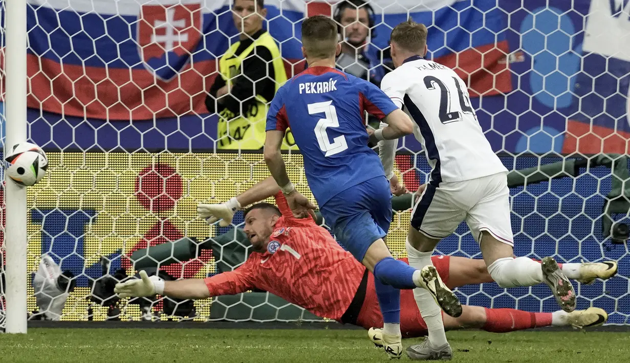 Kiper Timnas Slovakia, Martin Dubravka berusaha menjangkau bola hasil tendangan gelandang Timnas Inggris, Declan Rice pada laga babak 16 besar Euro 2024 di Arena AufSchalke, Gelsenkirchen, Jerman, Minggu (30/6/2024). (AP Photo/Thanassis Stavrakis)