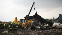 Tim penyelamat berusaha mengangkat puing pesawat yang jatuh di dekat Bandara Internasional Kathmandu, Nepal, Senin (12/3). Pesawat yang kecelakaan merupakan maskapai US-Bangla Airlines. (Prakash MATHEMA/AFP)